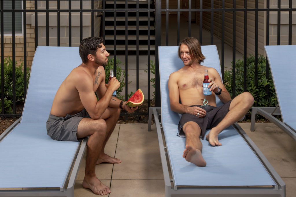 guys sitting in chairs on pool deck at evolve community