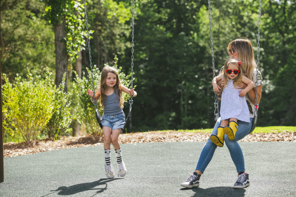 family on swings at evolve community playground