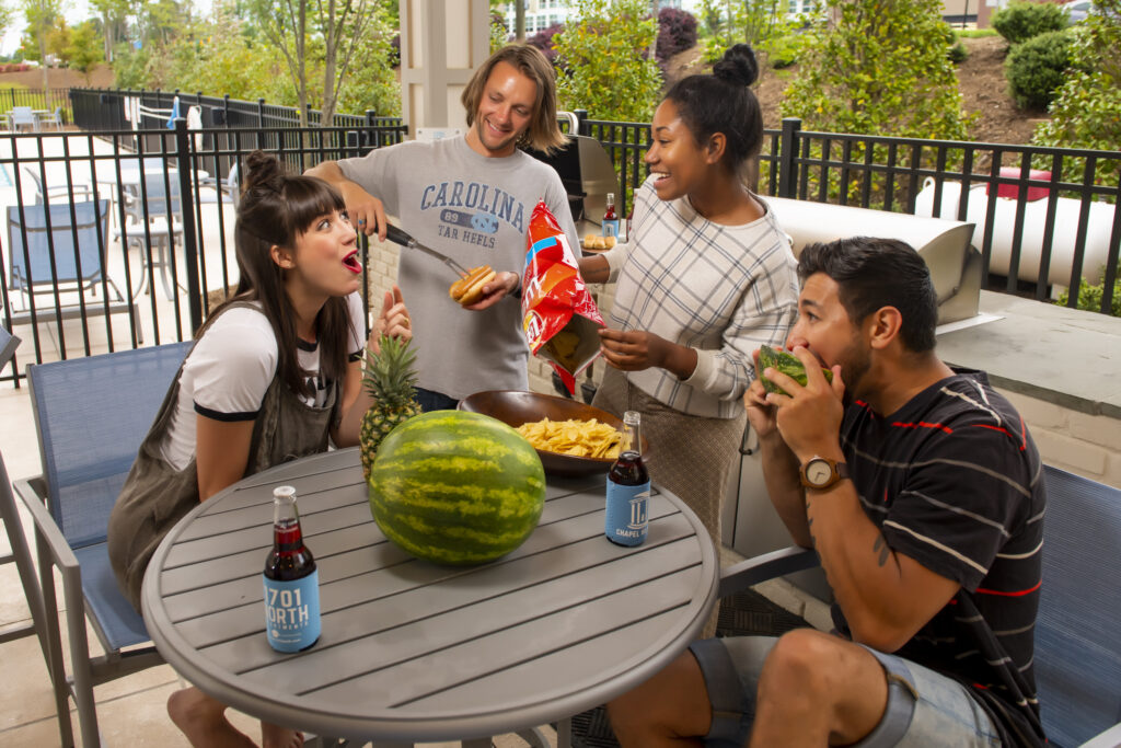 people grilling at pool evolve