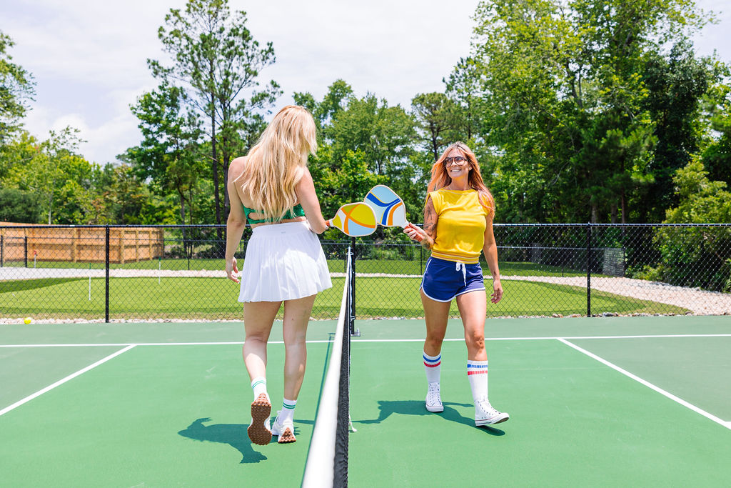 girls high-fiving on the pickleball court
